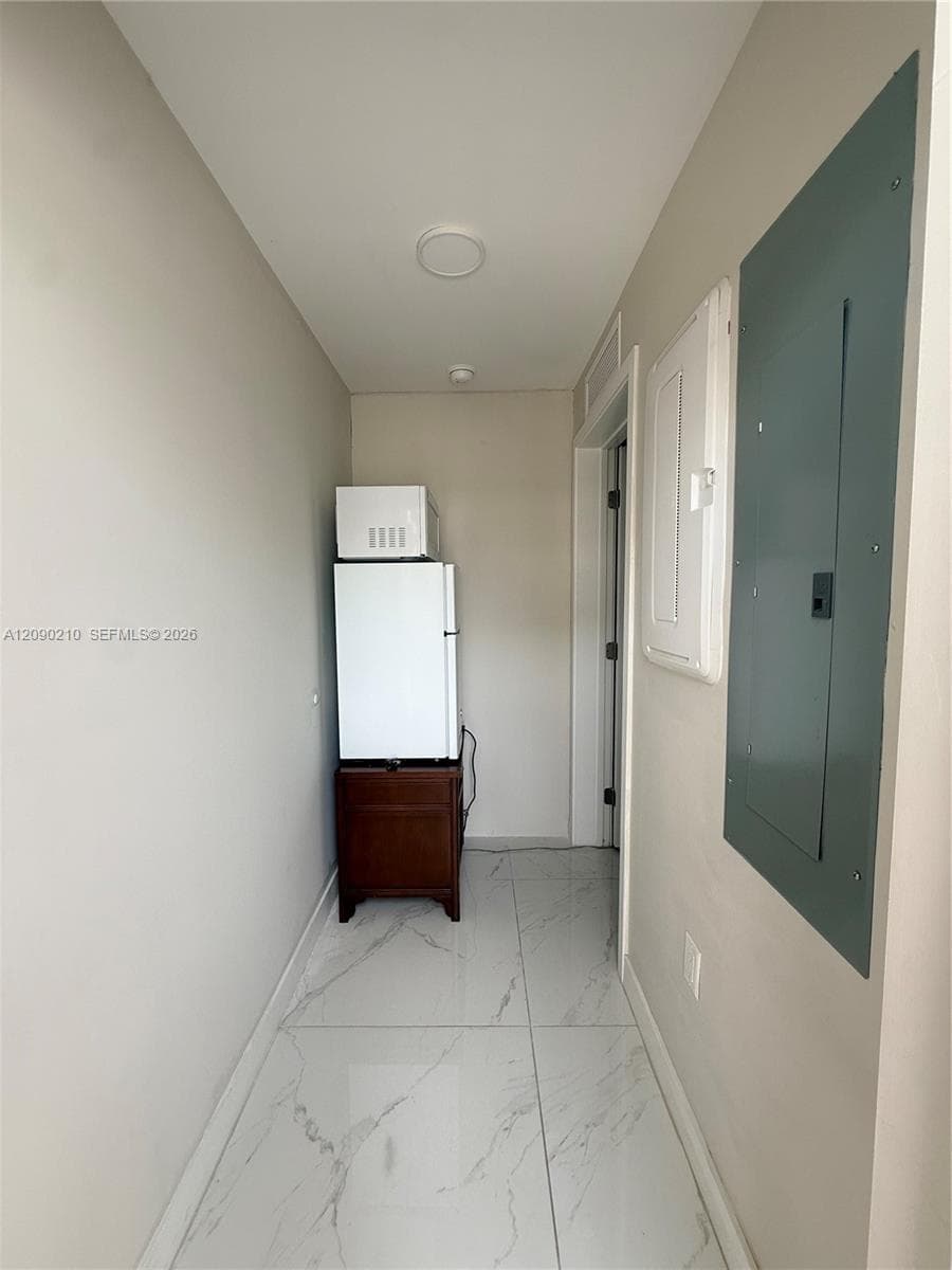 Hallway featuring large-format porcelain tile flooring with grey veining and recessed ceiling lighting