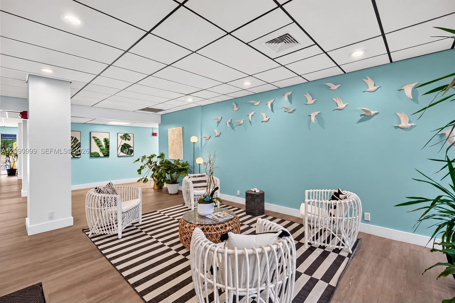 Suspended acoustic tile ceiling with recessed lighting and wood-finish flooring