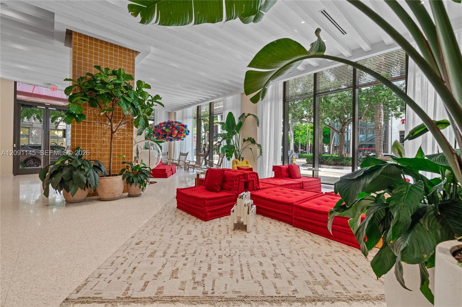 Spacious lobby featuring large format tile flooring, a statement tiled pillar, and extensive floor-to-ceiling windows