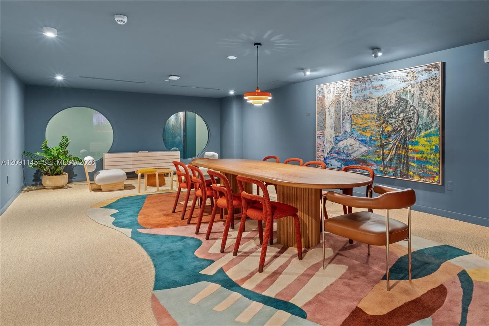 Recessed lighting throughout, two circular wall cutouts, and a contemporary pendant light fixture