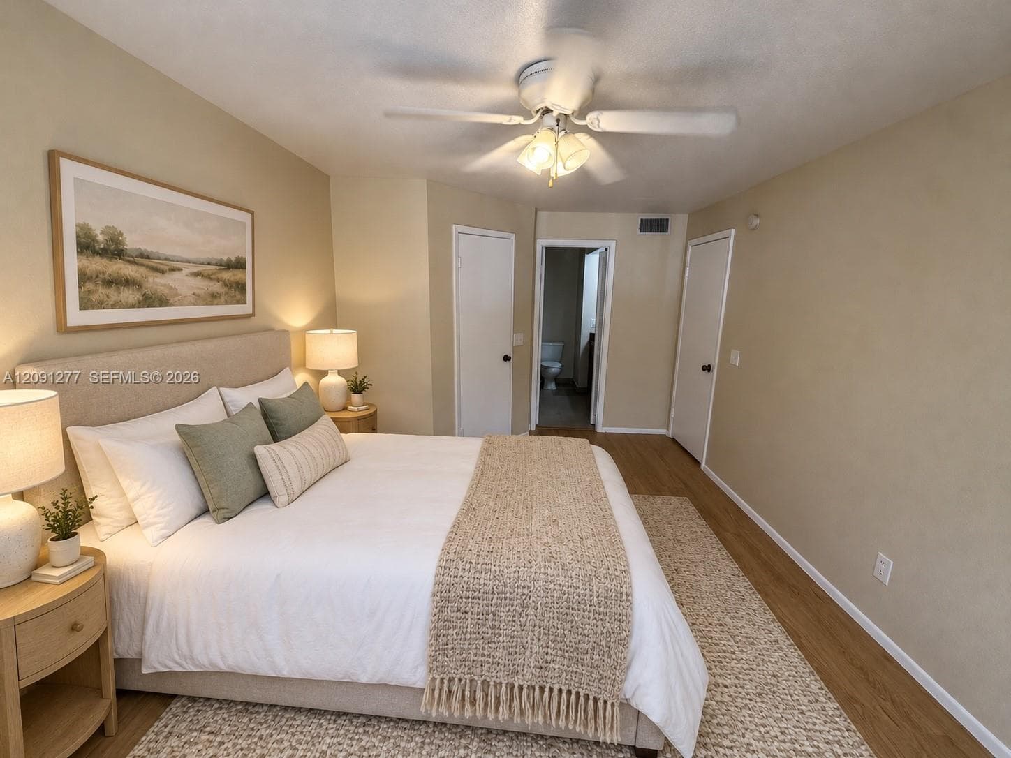Wood-finish flooring, ceiling fan with integrated light fixture, and dual interior doors