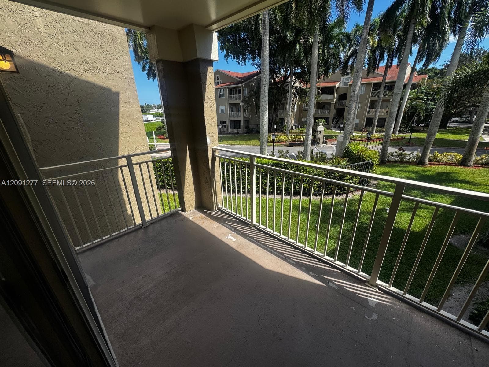 Covered balcony featuring concrete flooring and metal railings