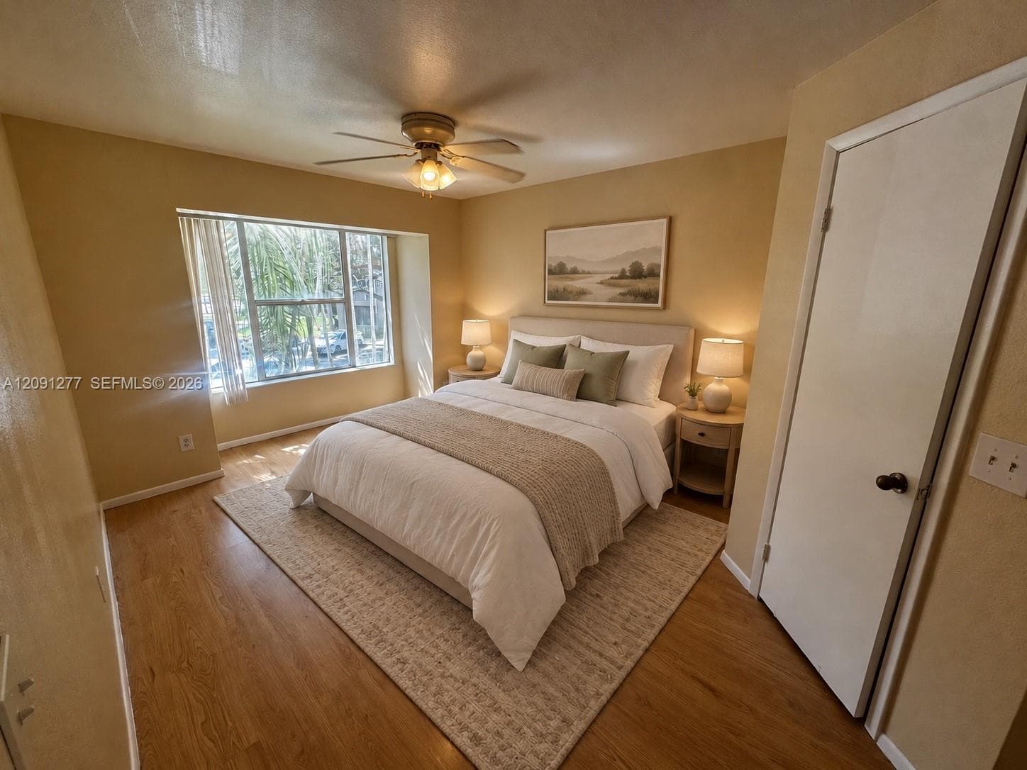 Wood-finish flooring, recessed window bay, and ceiling fan with integrated lighting