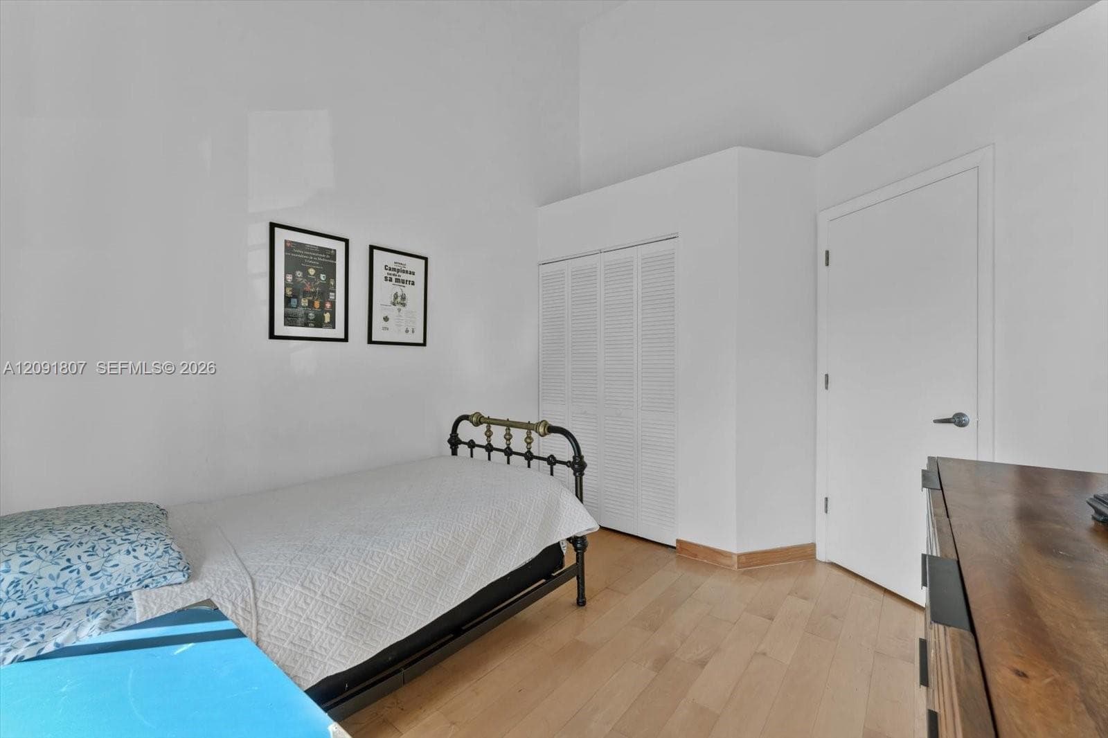 High ceilings, light-toned wood-finish flooring, and a closet with louvered bi-fold doors
