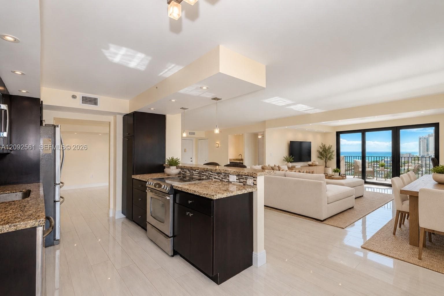 Kitchen featuring dark cabinetry, stone countertops, stainless steel appliances, recessed lighting, and large-format tile flooring