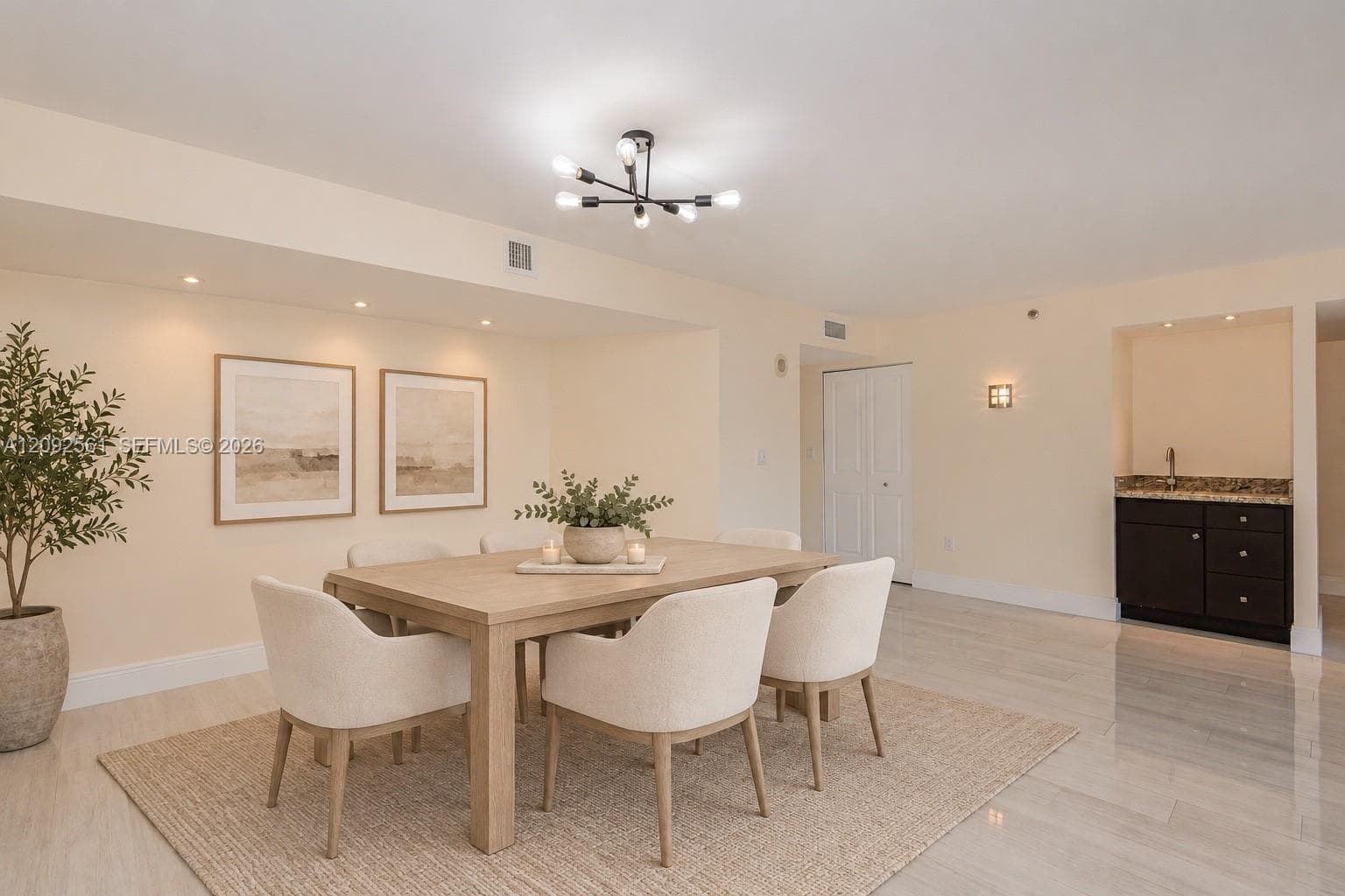 Dining area featuring stone-finish flooring, a multi-arm modern chandelier, recessed lighting, and a built-in wet bar with dark cabinetry and a stone countertop