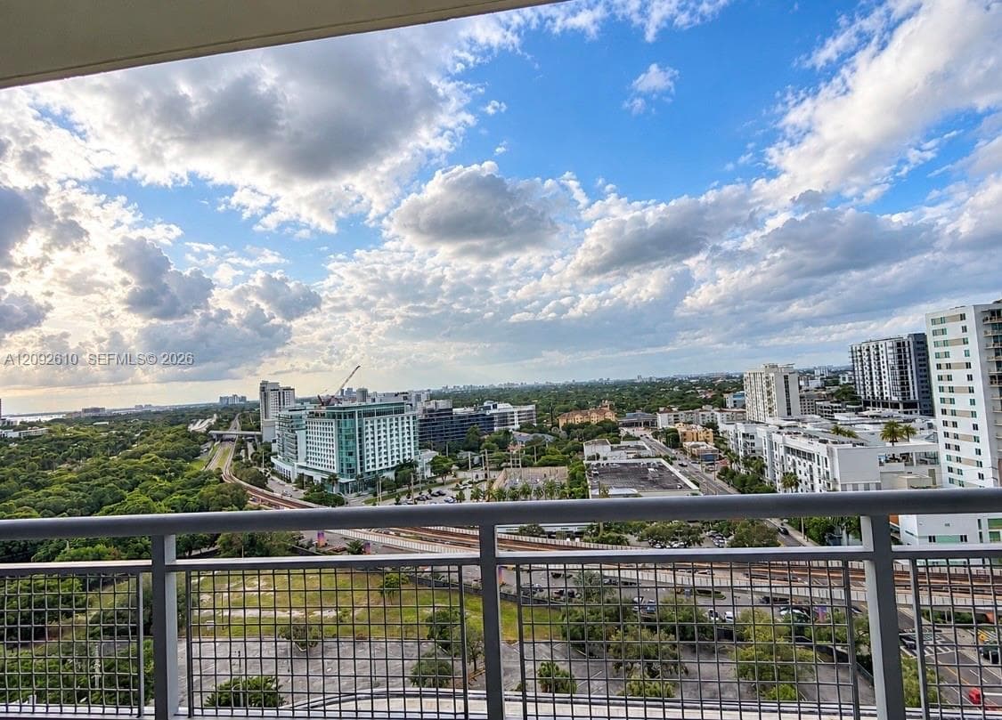 Elevated balcony featuring a metal safety railing and panoramic urban skyline scenery