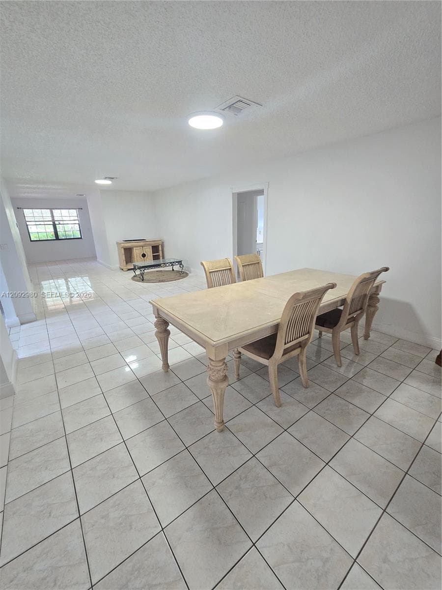 Neutral-toned ceramic tile flooring, clean white walls, and flush-mount ceiling lighting
