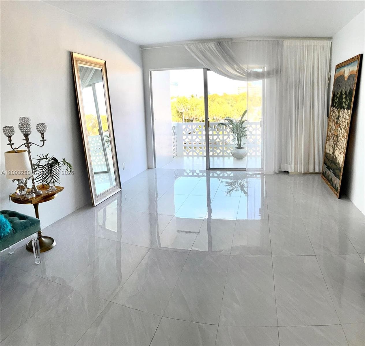 Polished tile flooring, white painted walls, and sliding glass doors with balcony access