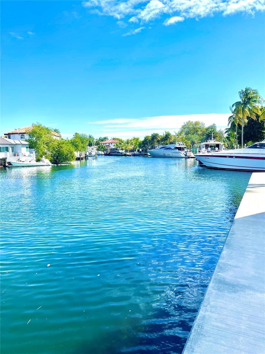 Waterfront property with concrete dockage and tropical landscaping
