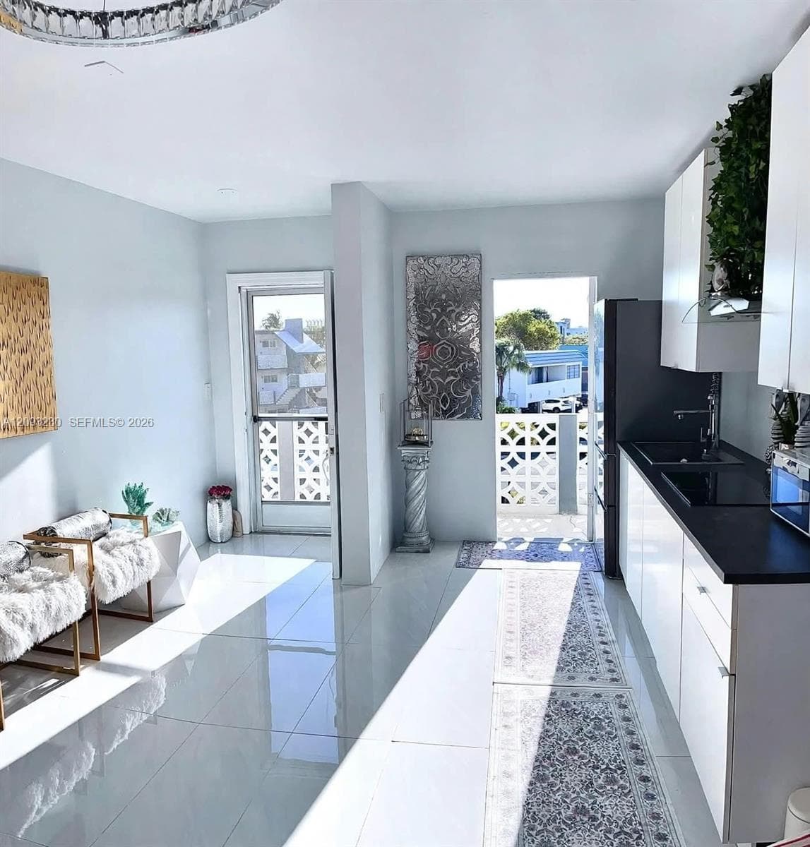 Integrated kitchen with white cabinetry and dark countertops
