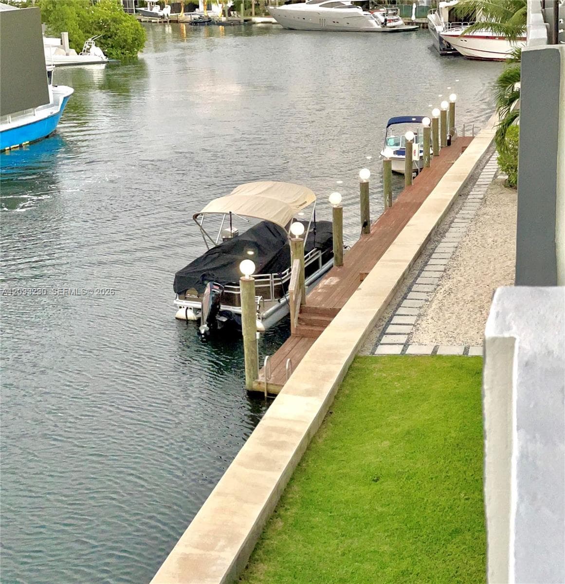 Private boat dock with integrated lighting, direct water access, and a manicured lawn