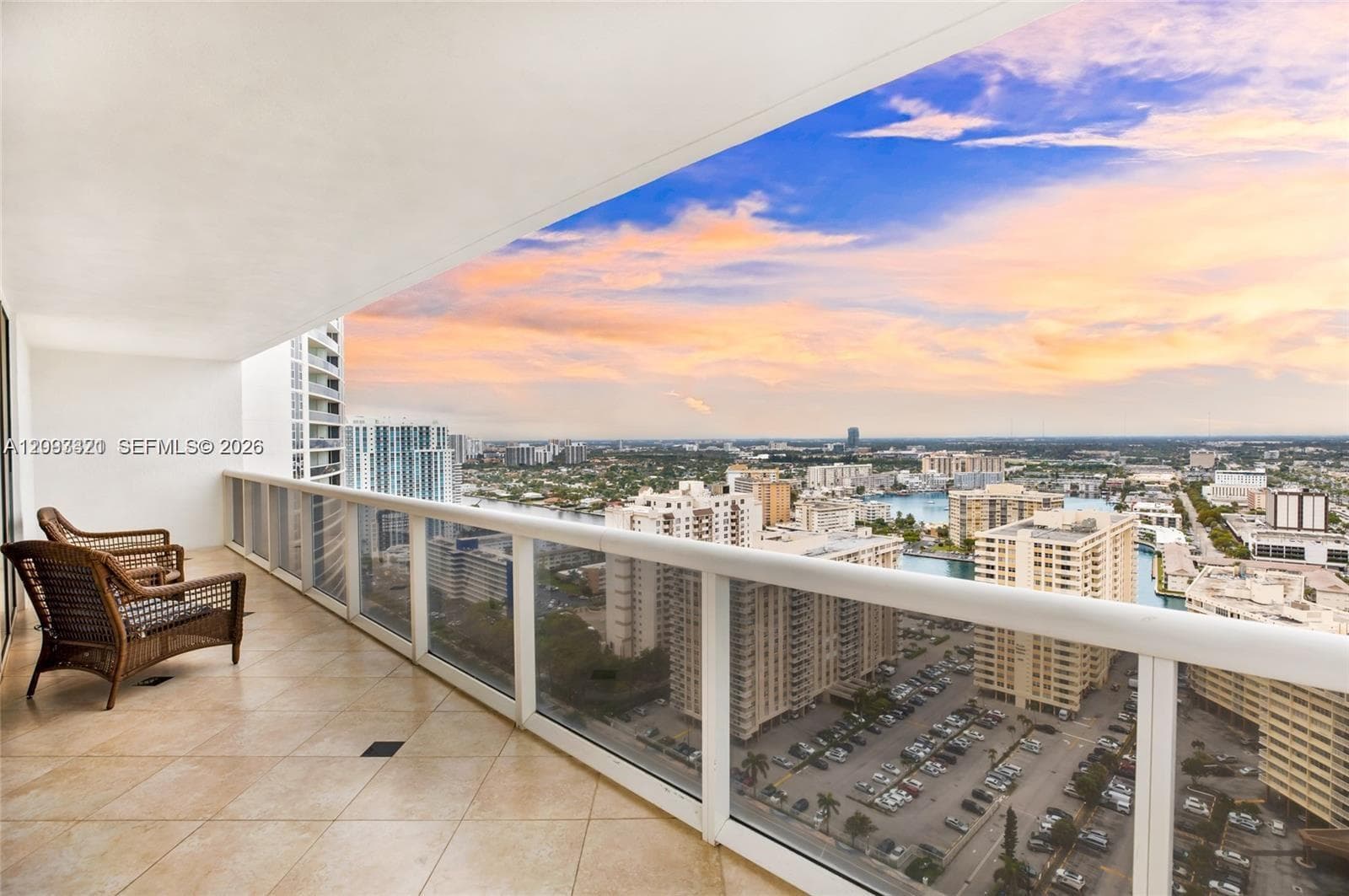 Spacious balcony featuring tile flooring and a glass railing system