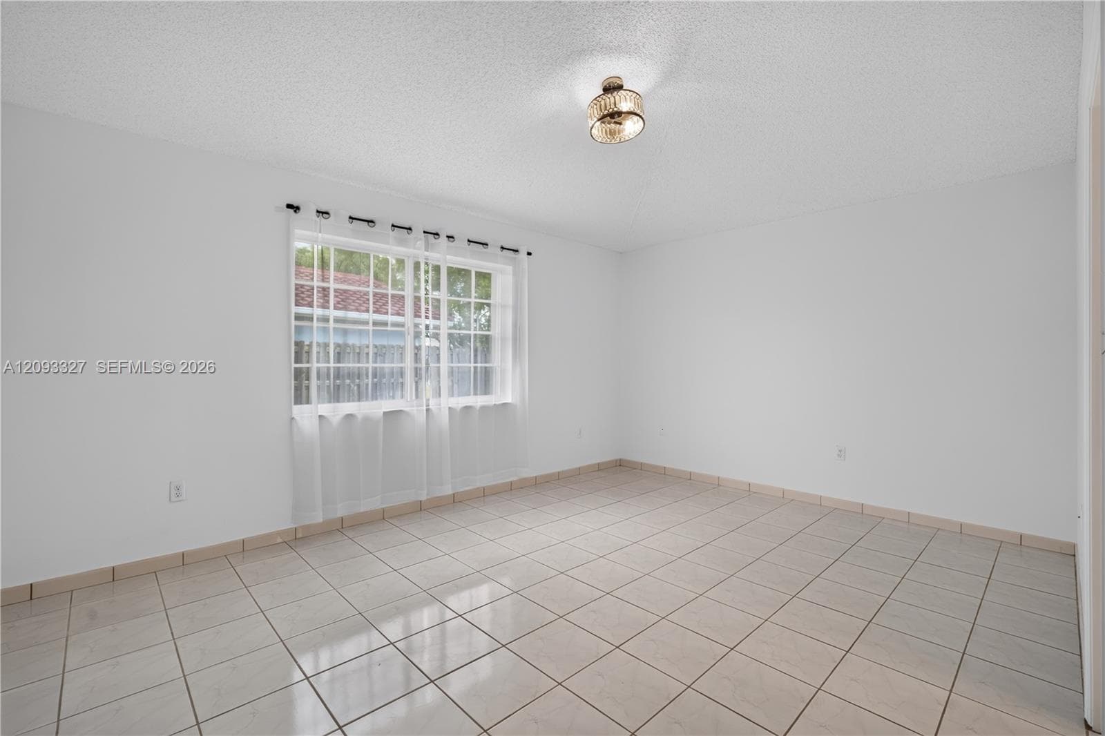 Neutral-toned ceramic tile flooring, clean white walls, multi-pane window with grid detailing, and a flush-mount drum ceiling light