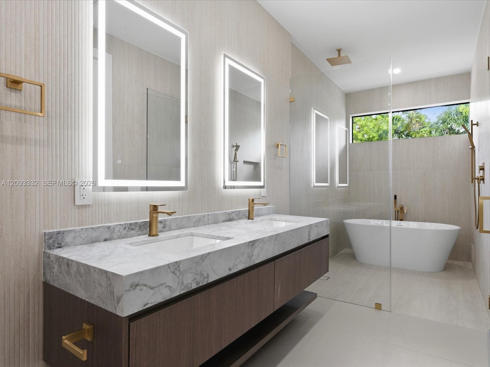Floating dual-sink vanity with stone countertop, brass-finish fixtures, dual LED-backlit mirrors, freestanding soaking tub, and glass-enclosed walk-in shower
