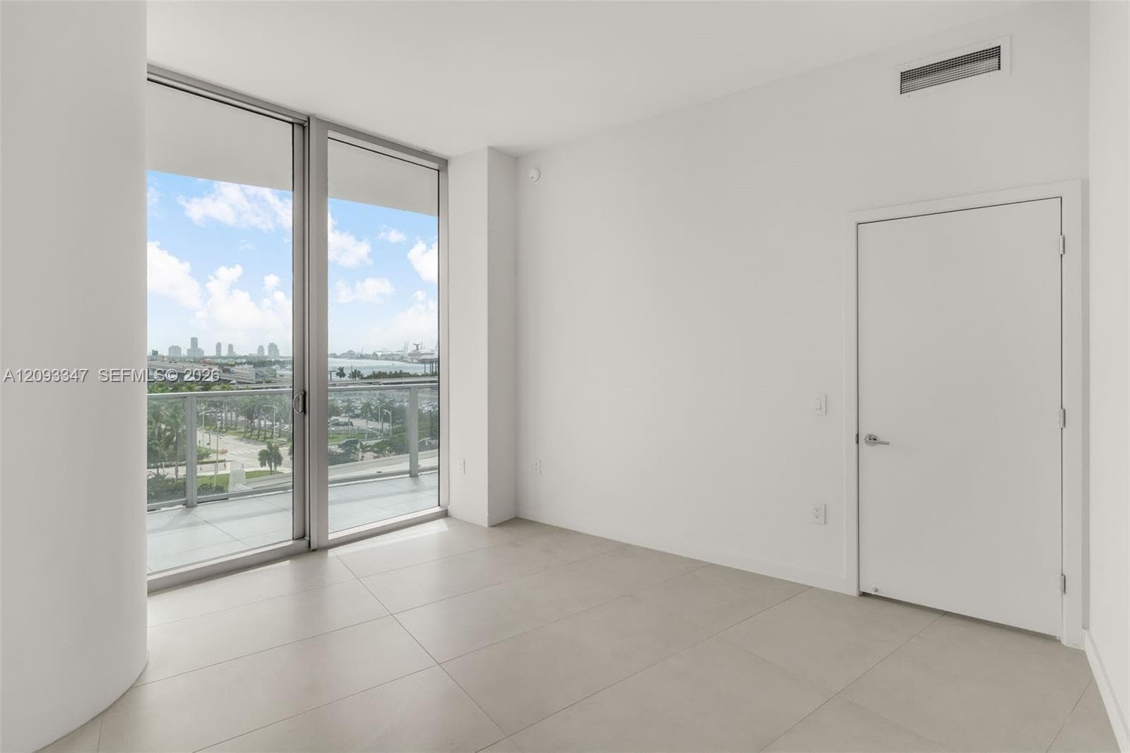 Primary bedroom with full height sliding glass and open park and bay outlook