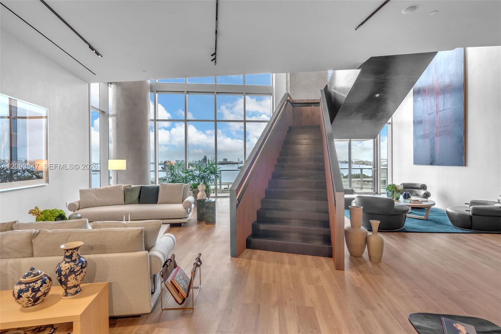 Two story social lounge with sculptural staircase and bay views