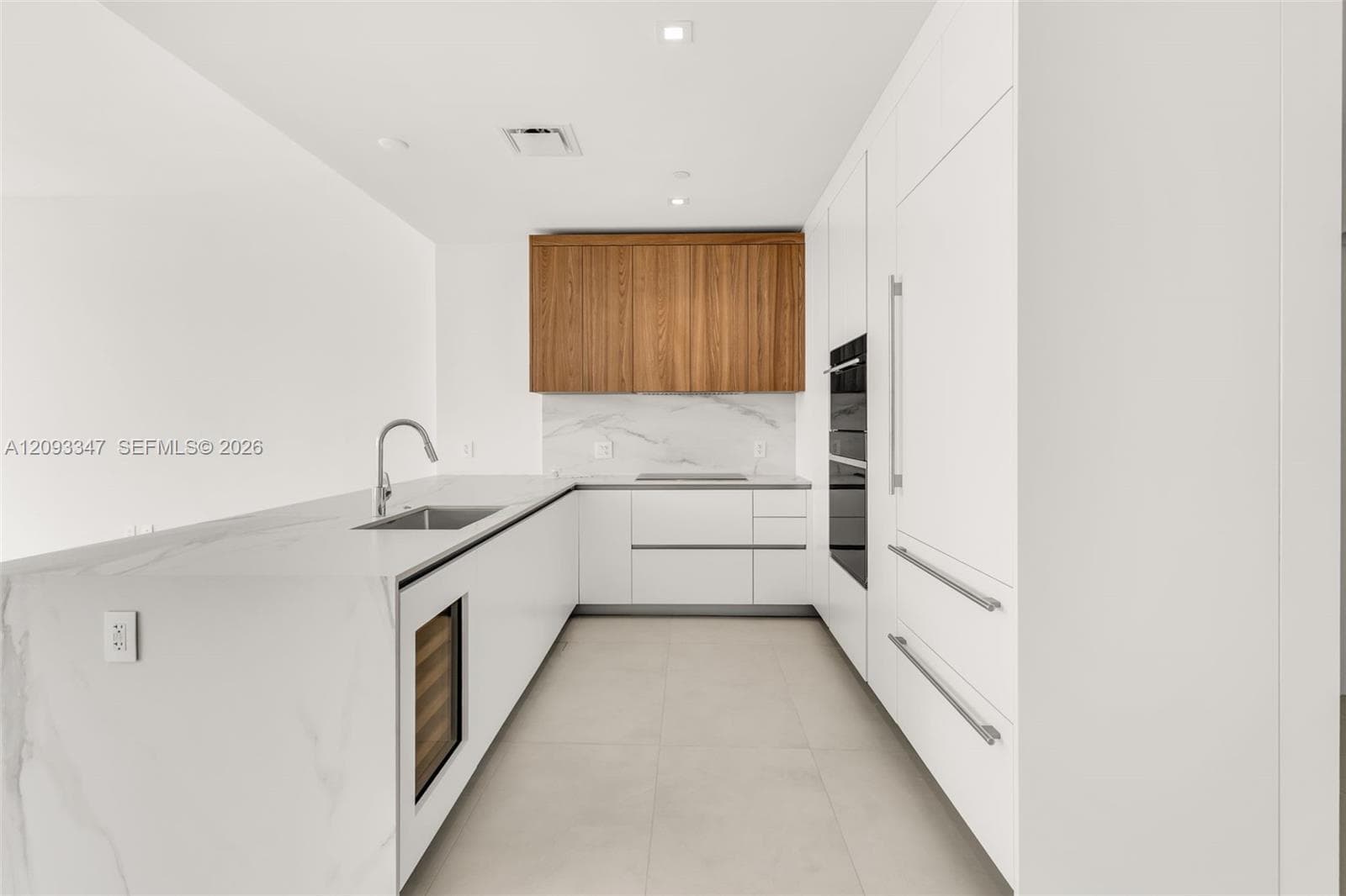 Sub-Zero and Wolf appliances with Cotton Crema porcelain and marble backsplash