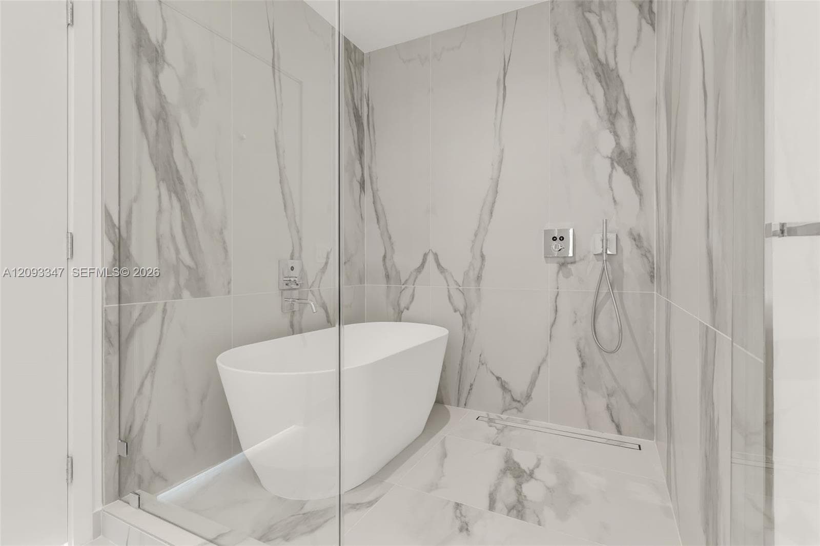 Freestanding soaking tub and glass enclosed rain shower in the primary bath