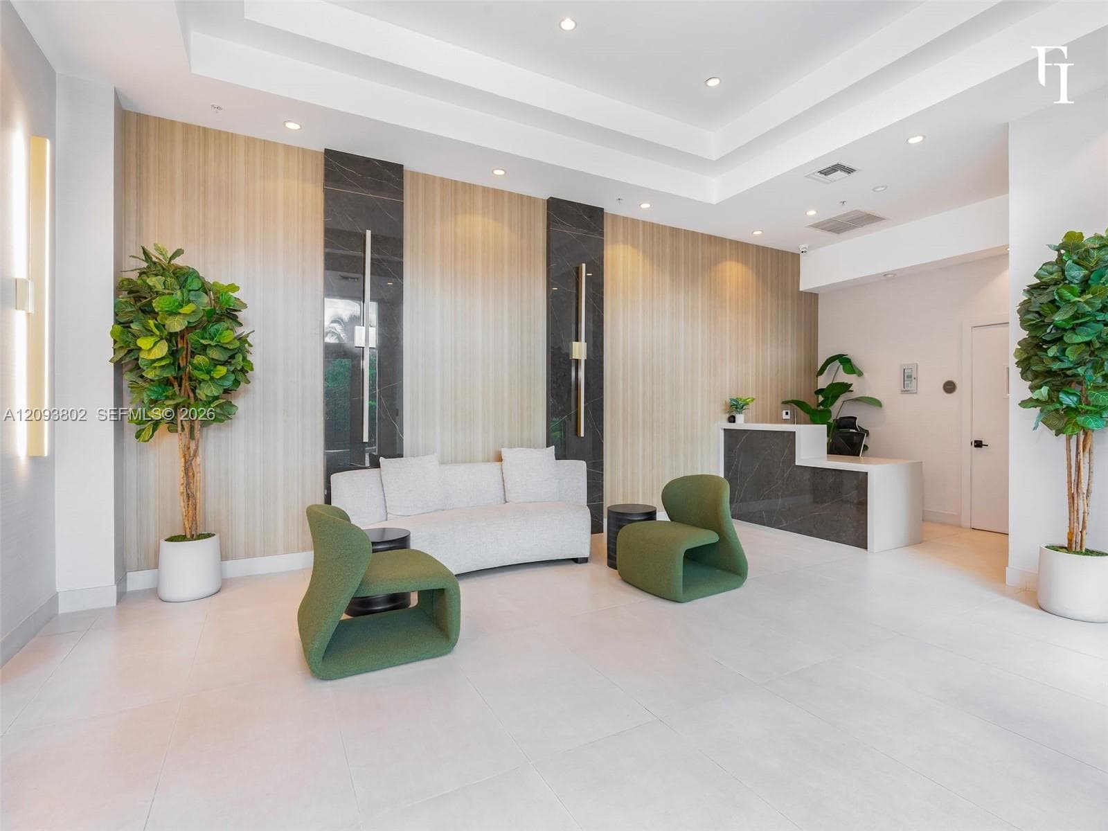 Lobby featuring a coffered ceiling, wood-finish wall paneling with dark stone accents, built-in reception desk, and large-format floor tile
