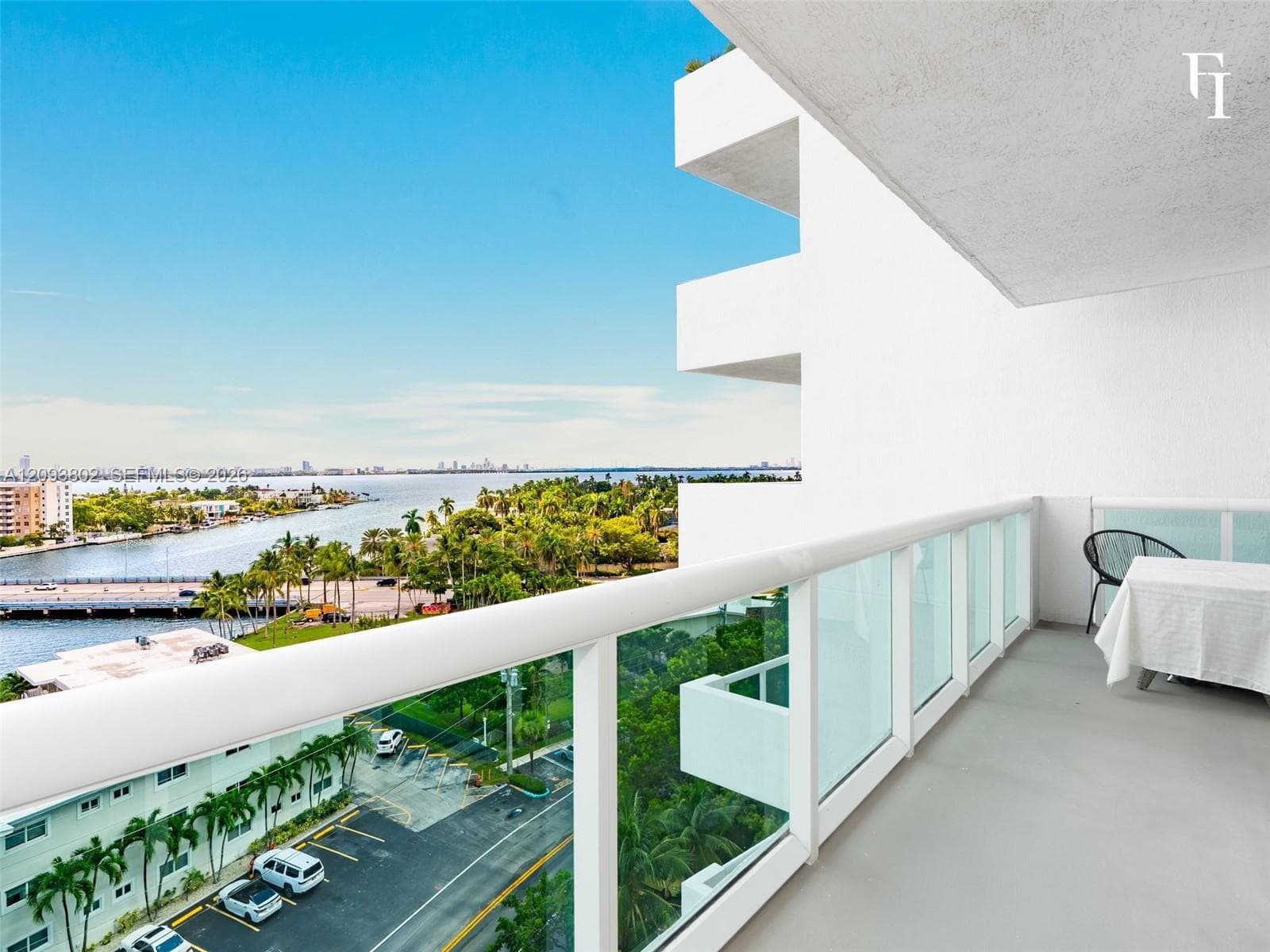 Private balcony featuring concrete flooring and a white glass-panel railing, offering a waterfront exposure