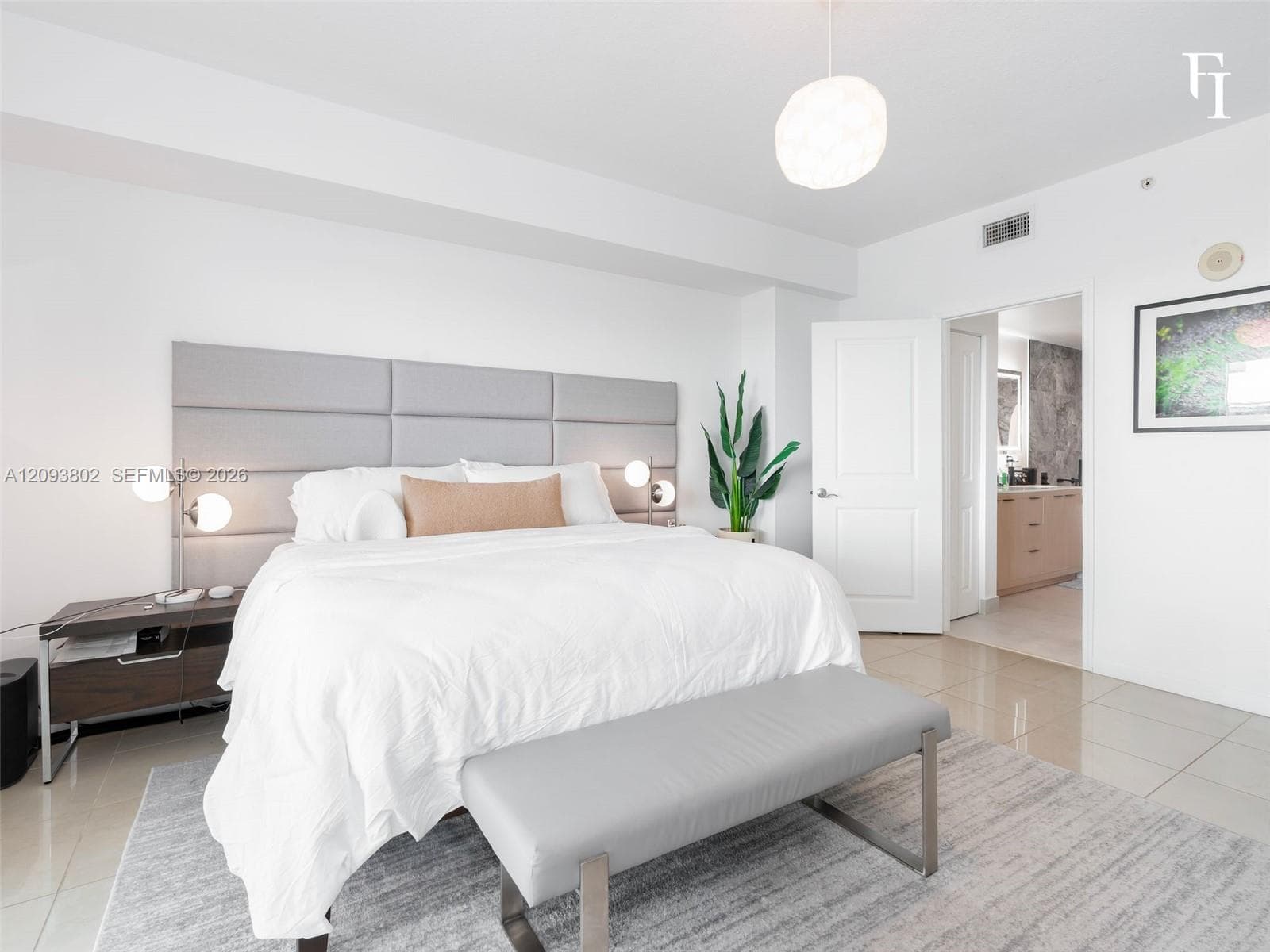 Large-format tile flooring, built-in panel headboard, and contemporary pendant lighting