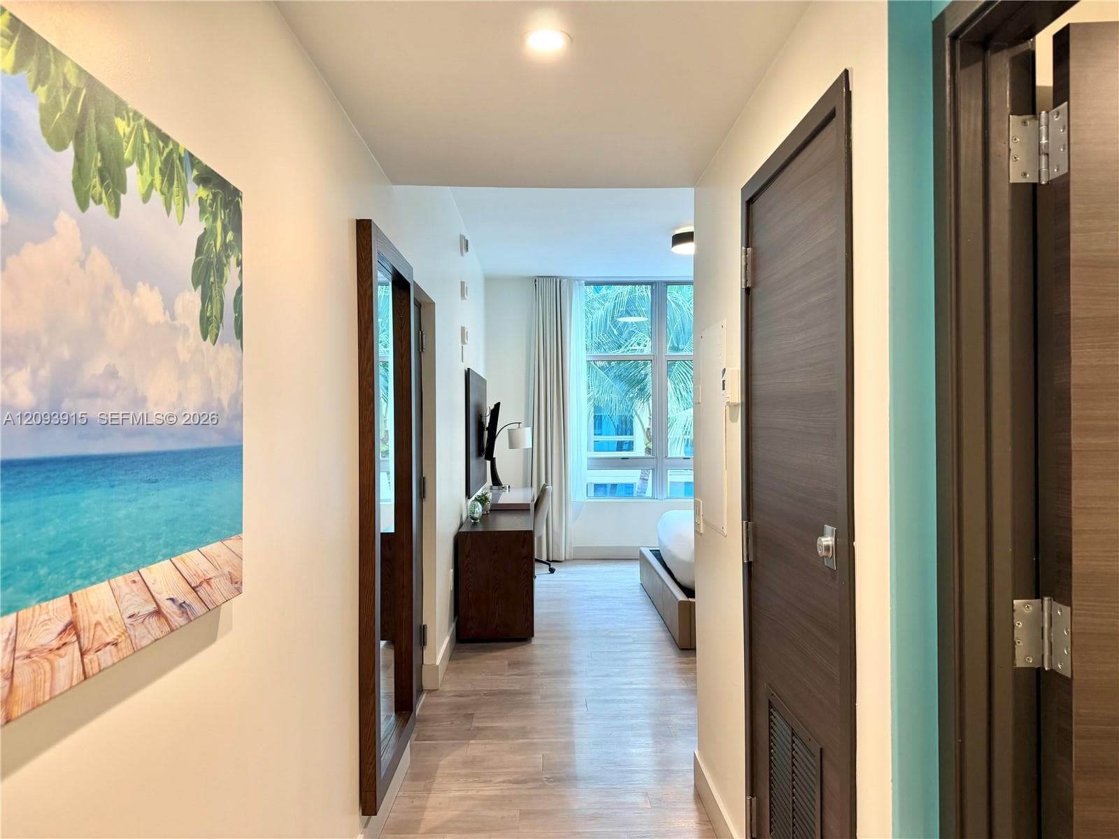 Wood-finish flooring, recessed lighting, and dark-finished doors with metallic hardware