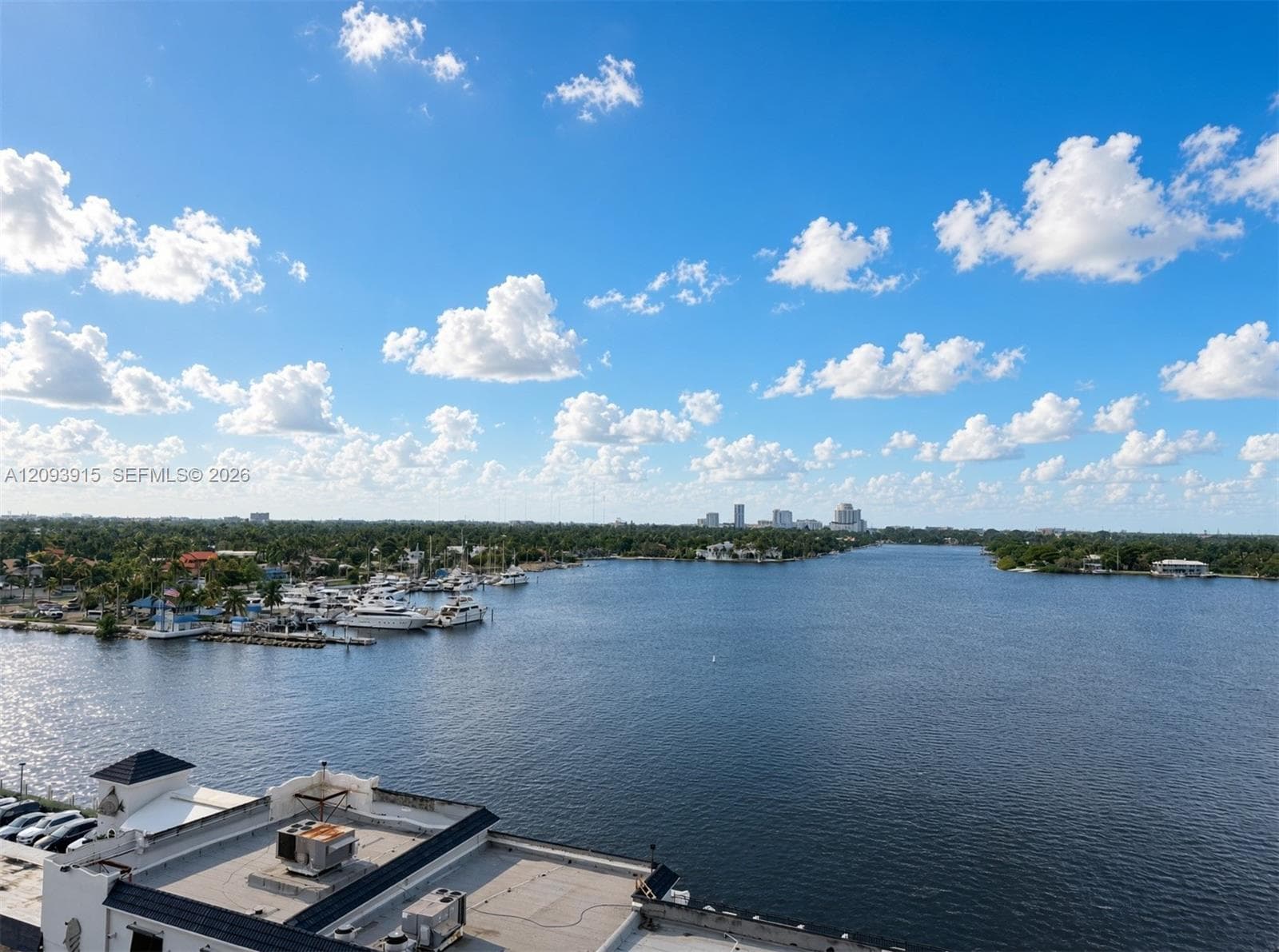 Panoramic coastal scenery featuring a waterway, marina, and distant cityscape