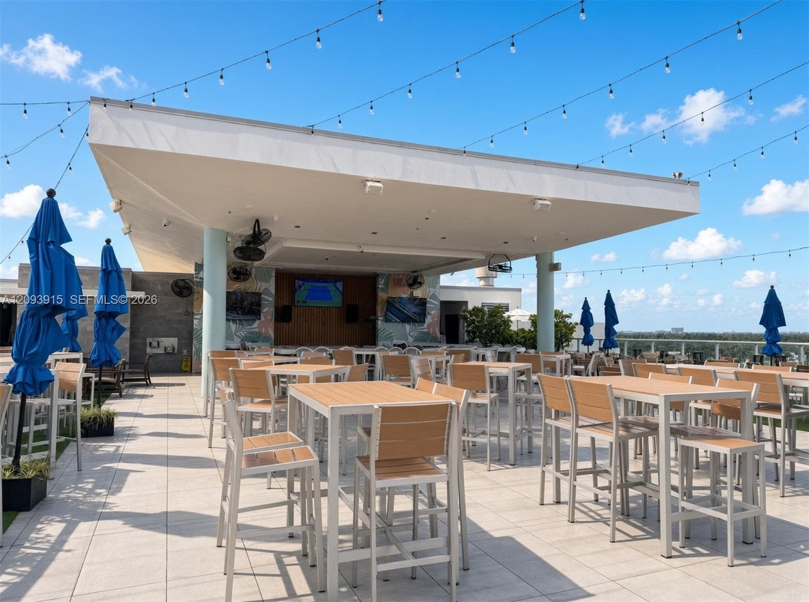 Rooftop terrace featuring a covered patio with overhead lighting, tile flooring, wall-mounted display screens, and ceiling-mounted fans