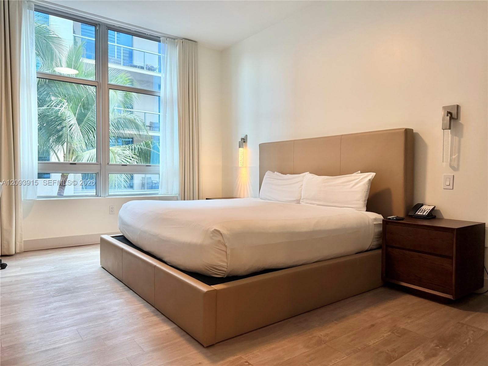 Floor-to-ceiling windows with expansive glass panels, neutral wall finish, and wood-finish flooring
