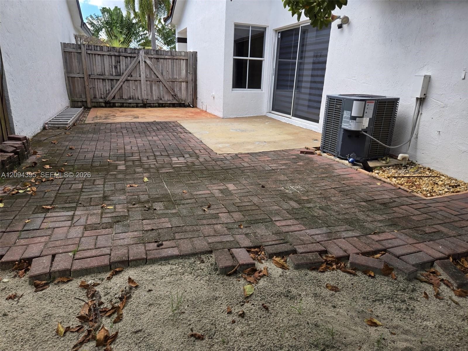 Exterior space featuring a brick-paver patio, concrete slab foundation, and a wood privacy fence
