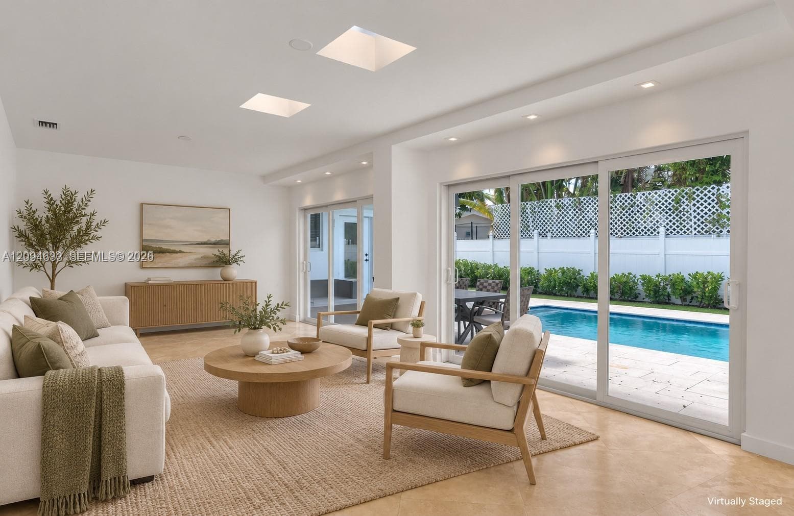 Living area featuring recessed lighting, skylights, tile flooring, and oversized sliding glass doors opening to a pool deck