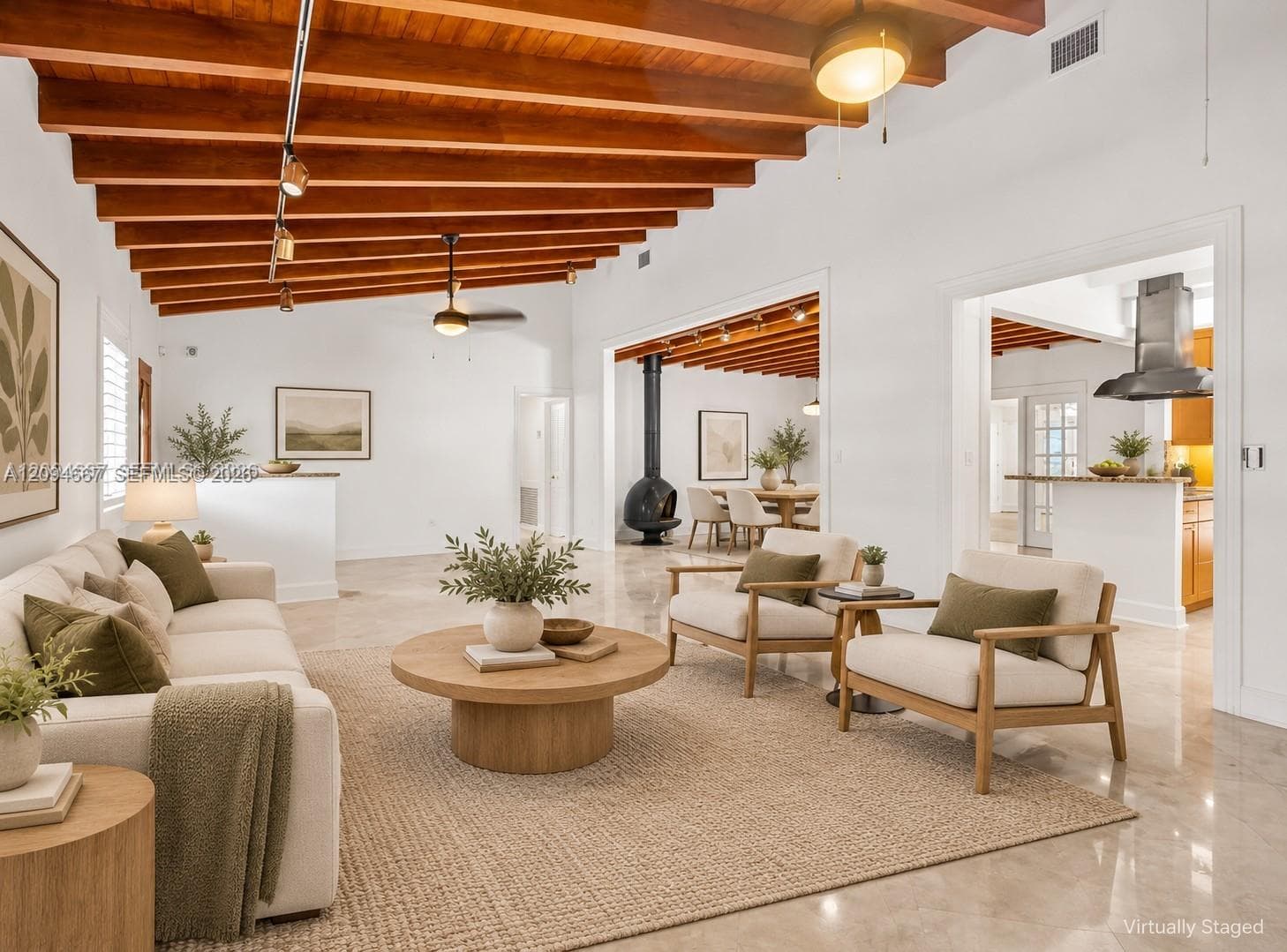 Exposed wood-beam ceiling, stone-finish flooring, and a freestanding black metal fireplace