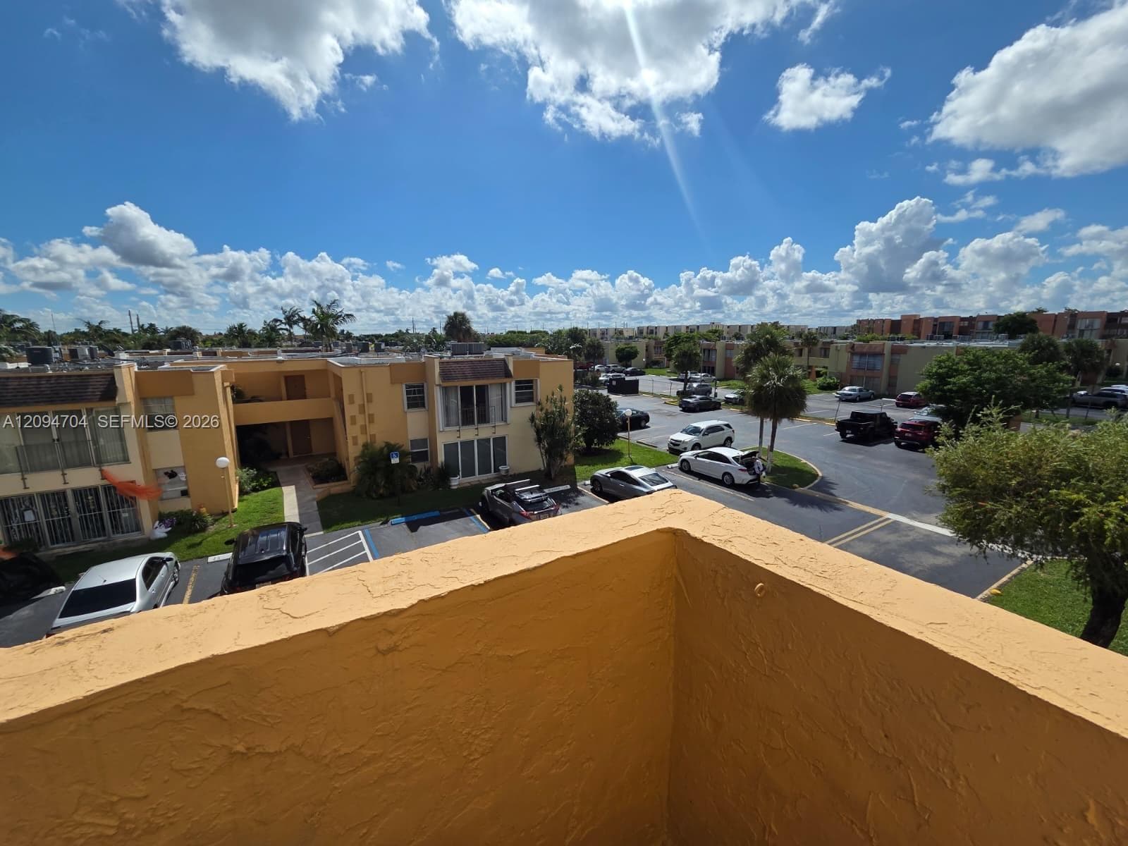 Exterior balcony featuring stucco wall finish and overhead outdoor exposure