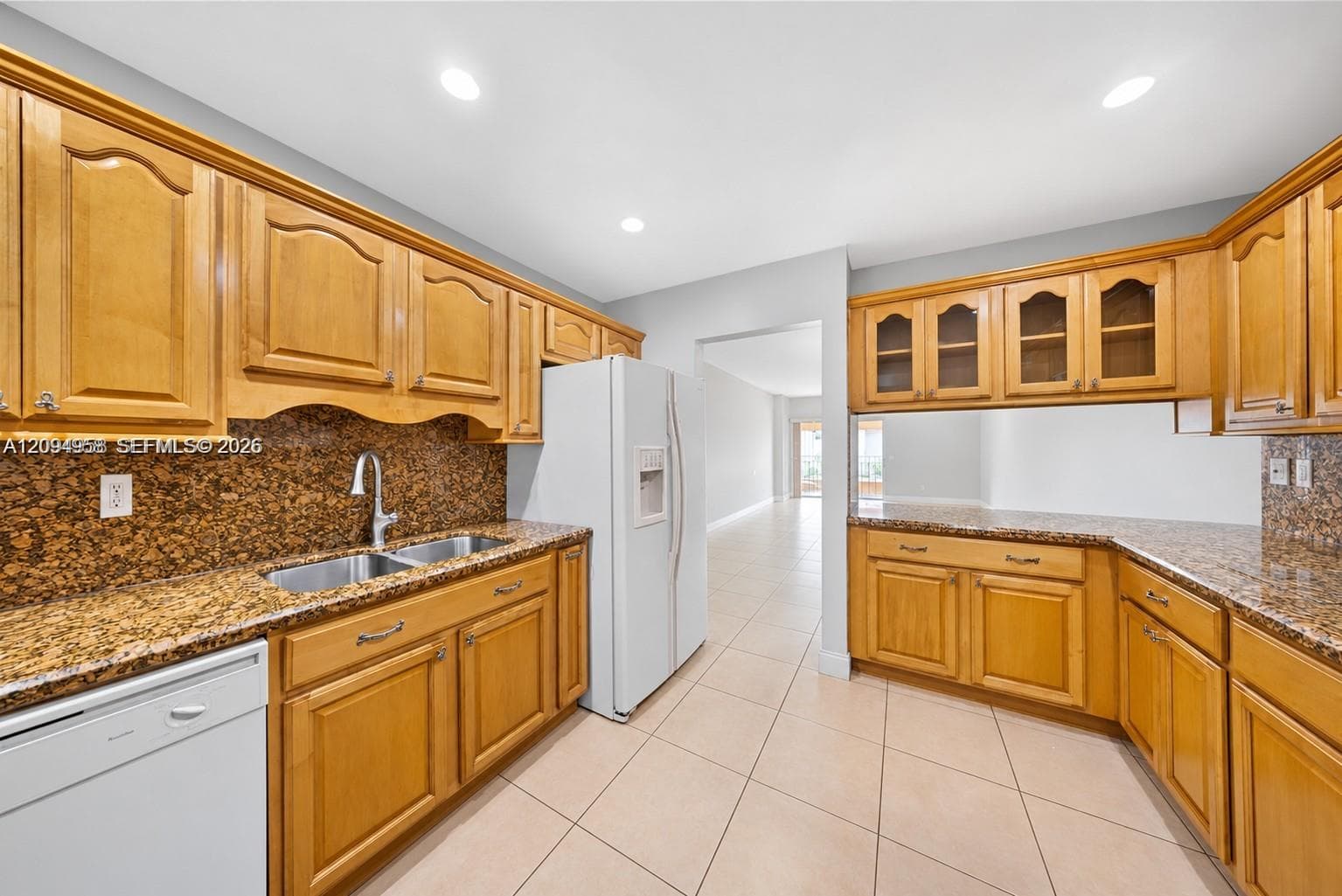 Kitchen featuring light wood cabinetry, stone-surface countertops, recessed lighting, and tile flooring