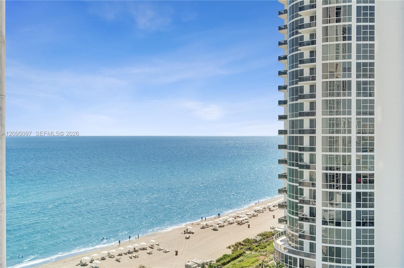 High-rise structure featuring floor-to-ceiling glass windows and private balconies overlooking the oceanfront