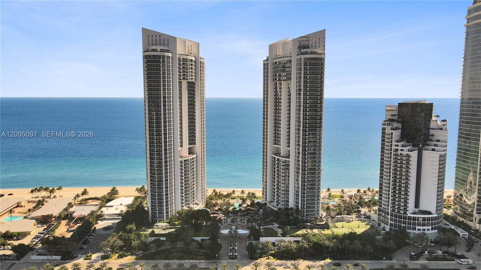 High-rise coastal towers featuring glass-paneled balconies and direct oceanfront positioning