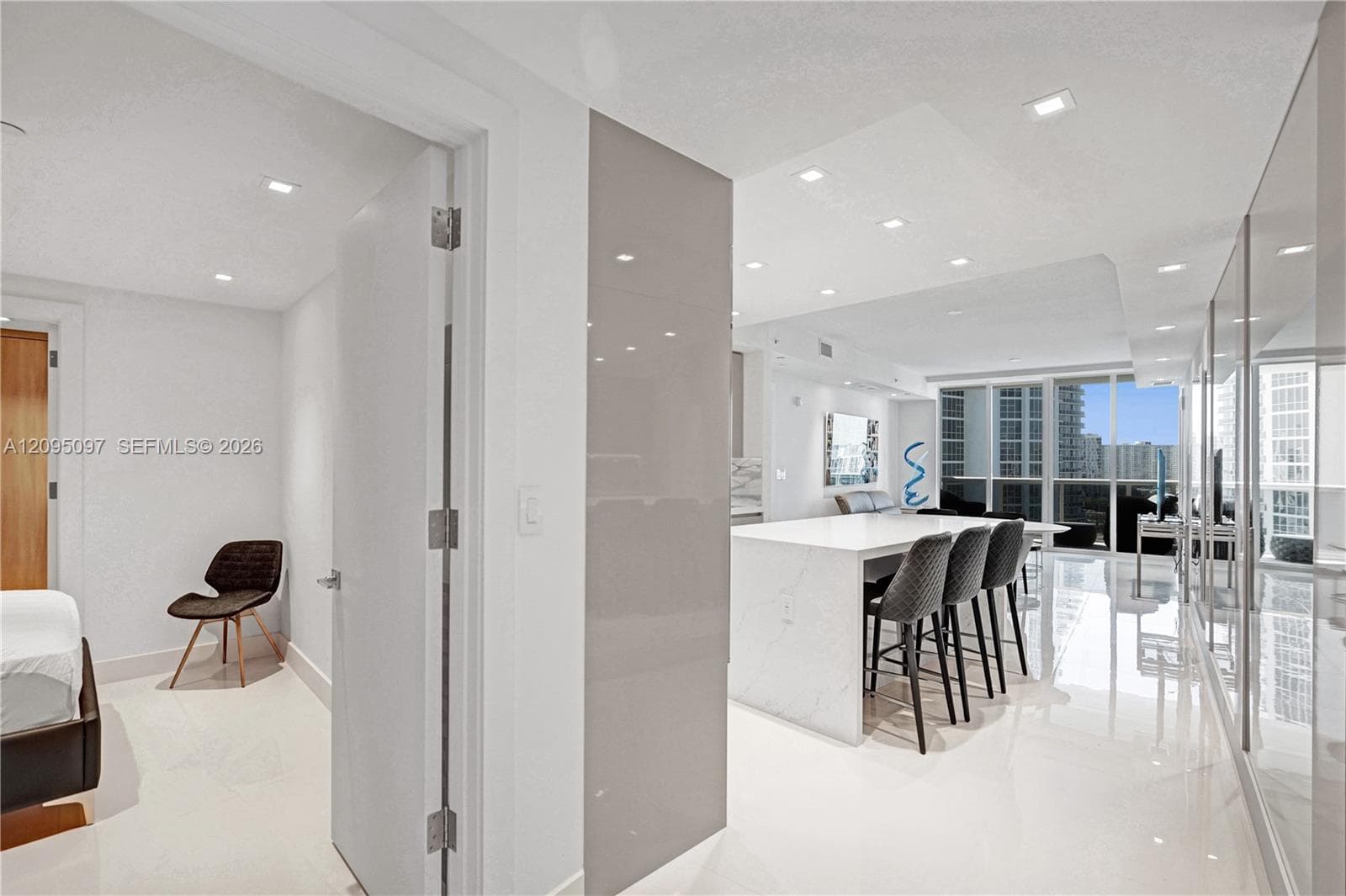 Kitchen island with waterfall countertop, recessed ceiling lighting, glossy wall paneling, polished flooring, and floor-to-ceiling windows