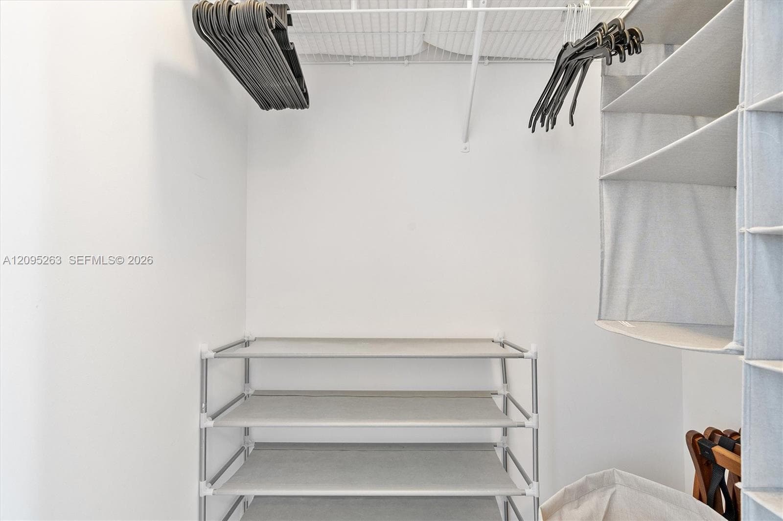 Storage space featuring white-coated wire shelving and a metal garment rod