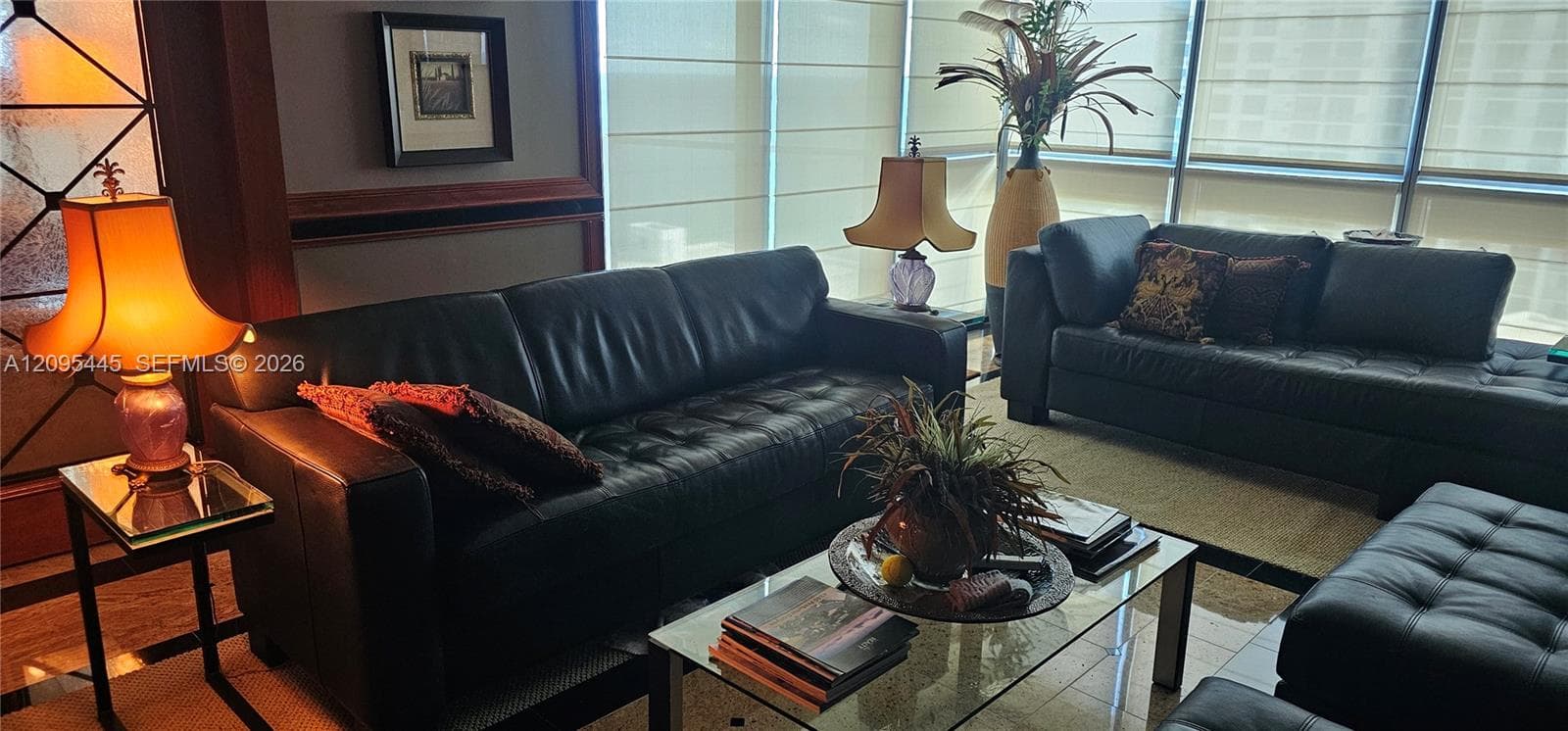 Floor-to-ceiling windows with retractable shades, polished stone flooring, and dark wood-tone architectural trim