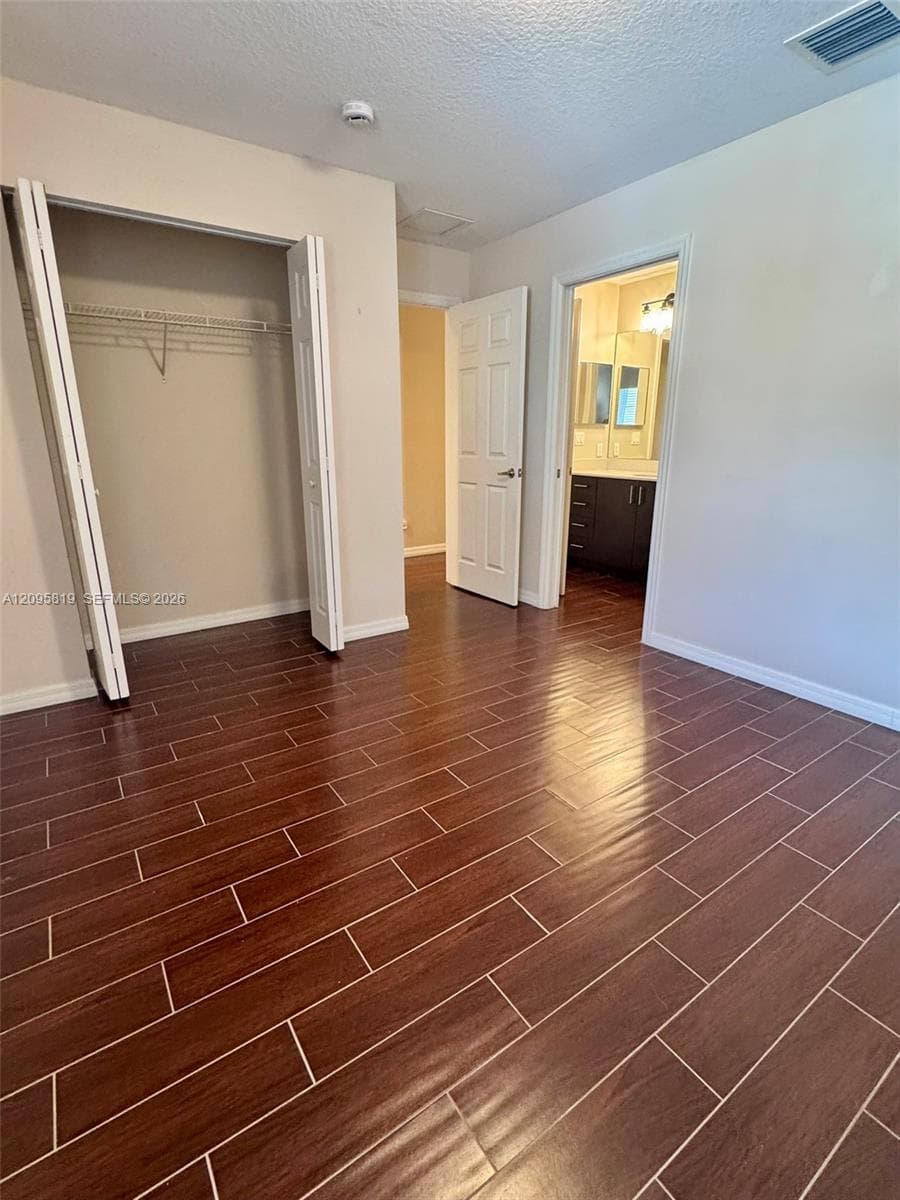 Room featuring wood-finish flooring, bi-fold closet doors, and solid-core interior doors