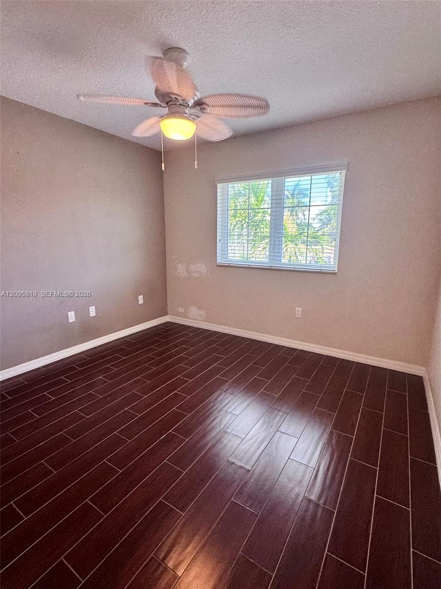 Wood-finish flooring, multi-pane window with integrated blinds, and ceiling fan with integrated light fixture