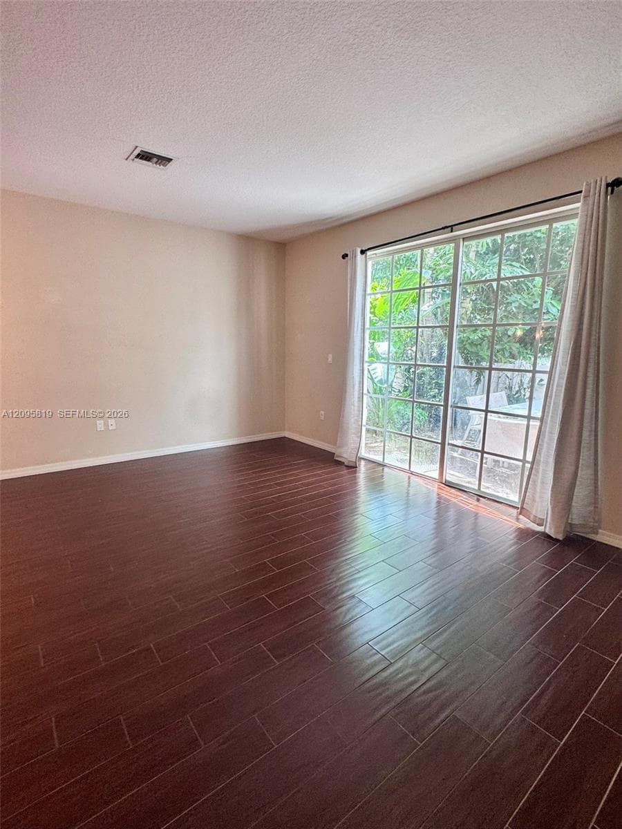 Interior space featuring wood-finish flooring and large sliding glass doors with grid detailing