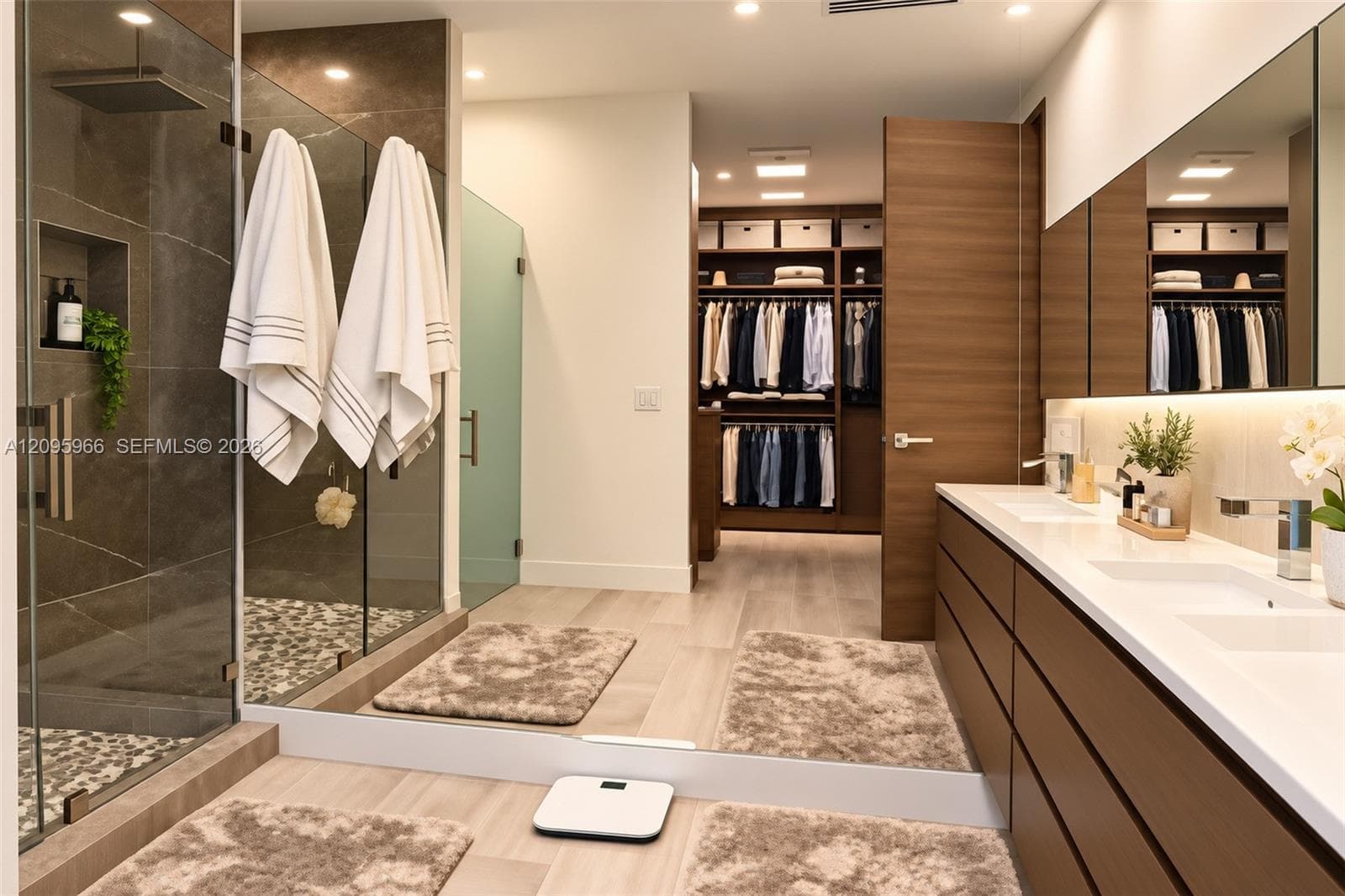 Walk-in shower with stone tile surround, pebble flooring, and integrated wall niche