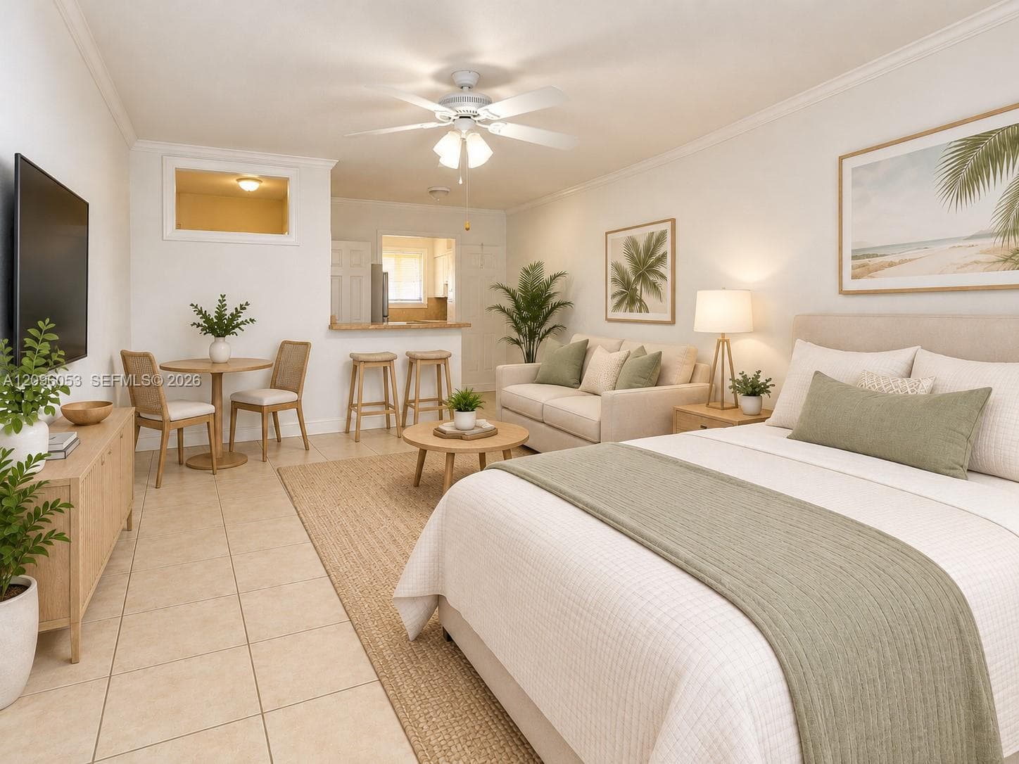 Open-concept studio space featuring large-format tile flooring, a breakfast bar with stone-finish countertop, crown molding, and a ceiling fan with integrated lighting