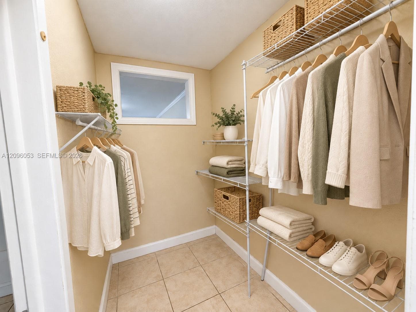 Walk-in closet featuring ceramic tile flooring, built-in wire shelving systems, and a wall-mounted window
