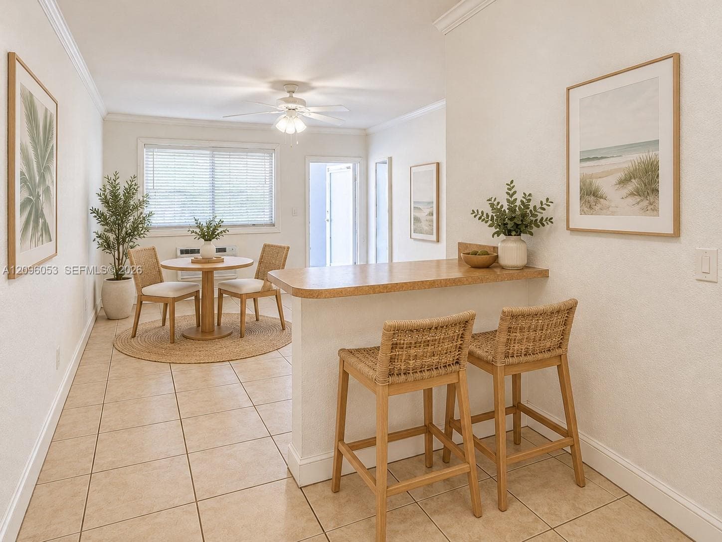 Ceramic tile flooring, breakfast bar with a solid surface countertop, crown molding, and ceiling fan with integrated light fixture