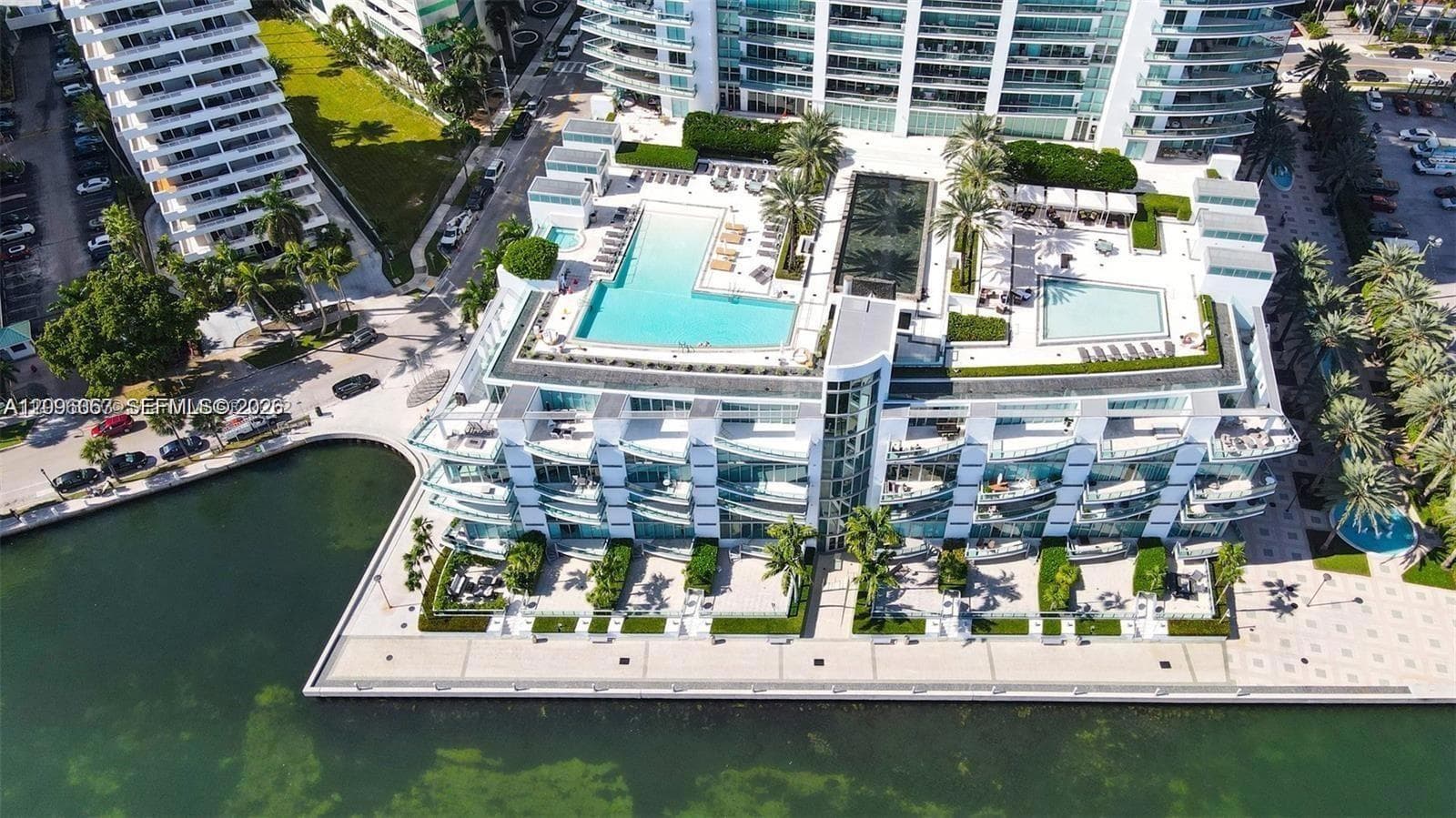 Rooftop amenities featuring multiple swimming pools, structured landscaping, and a waterfront promenade