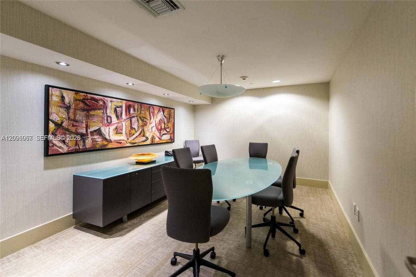 Recessed lighting with a suspended ceiling fixture, wall-mounted console cabinetry, and patterned wall covering