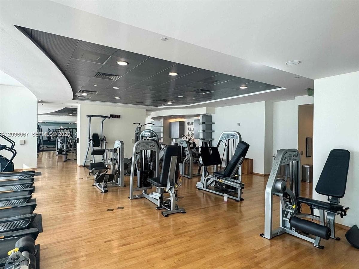 Spacious fitness center featuring wood-finish flooring, recessed lighting, and a variety of exercise equipment